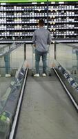 A customer with a trolley on escalator in a construction store. Vertical video