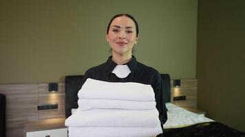 Chambermaid or housemaid with white linen and towels in her hands video