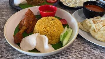 Nasi goreng with chicken rendang. Fried rice asian popular food served with cucumber slices and crackers. video