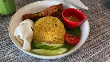 Nasi goreng with chicken rendang. Fried rice asian popular food served with cucumber slices and crackers. video