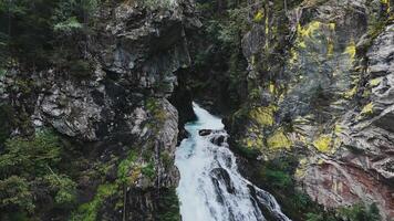 Water flows over a cliff and crashes down into a pool below video