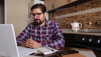 Young man freelancer student using laptop studying online working from home in internet, smiling focused millennial guy typing on computer surfing web looking at screen enjoying distant job video