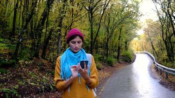 Woman with Backpack Using Smartphone, Hiking In The Forest And Typing Message On Smartphone. Solo female hiker using smart phone. Female hiker takes smart phone pic of mountains and forest. video