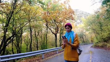 Woman with Backpack Using Smartphone, Hiking In The Forest And Typing Message On Smartphone. Solo female hiker using smart phone. Female hiker takes smart phone pic of mountains and forest. video