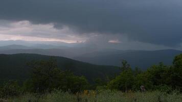 storm is coming - dramatic rain clouds approach the hill. Storm clouds rolling in the sky during rain storm it moves across the landscape and lightning strikes during severe storm video