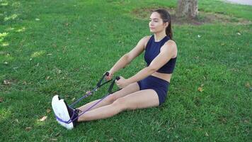 uma mulher exercícios com resistência bandas dentro uma parque, concentrando em resistência, flexibilidade, e ginástica video
