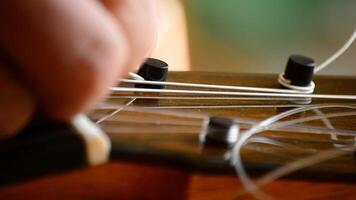 Luthier placing the string of a guitar, close up video