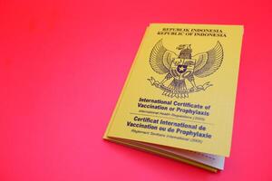 international certificate of vaccination or prophylaxis isolated on green background. yellow book as a sign of vaccination. yellow book of vaccines from indonesia photo