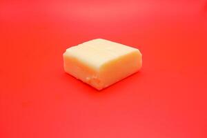 cube shaped cheese isolated on red background. mozzarella cheese that melts easily photo