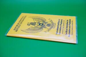 international certificate of vaccination or prophylaxis isolated on green background. yellow book as a sign of vaccination. yellow book of vaccines from indonesia photo