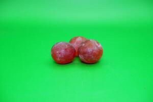 3 grapes isolated on green background. Fresh purple grapes. photo