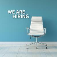 A sleek white office chair in an empty minimalist space with the text We Are Hiring written above it on a blue wall. Hiring announcement social media post design. photo