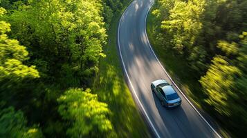 Car in rural area in deep rain forest with green tree view from above, Aerial view of a car in open path road with speed motion background. photo