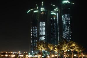 a large group of tall buildings at night photo