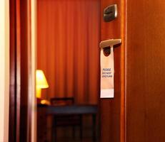 Please do not disturb sign hanging on open door photo