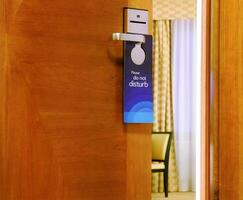 Please do not disturb sign hanging on open door photo