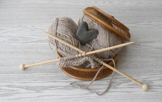 a basket with knitting needles and yarn photo