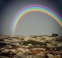Rainbow above a lonly house photo