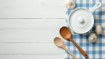Cooking utensils on white wooden table banner background copy space. Saucepan, garlics and spoon in kitchen image backdrop empty. Food preparation concept composition top view, copyspace photo