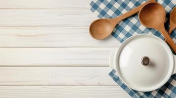 Stewpot with spoons and ladle on table banner background copy space. Pot with lid and utensils image backdrop empty. Cooking food at home concept composition top view, copyspace photo