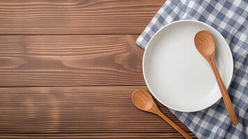 Plate with spoons and towel on table banner background copy space. Country kitchen setting with utensils image backdrop empty. Cookery tools concept composition top view, copyspace photo