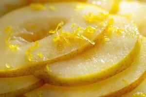 Slices of fresh yellow pears with citrus zest garnish on a bright kitchen surface photo