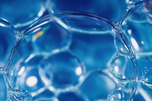 Close-up view of soap bubbles floating in clear blue liquid with reflections and texture photo