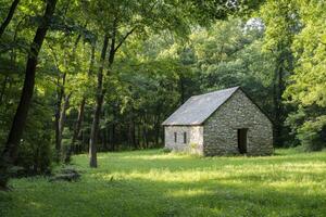 Rustic stone building nestled in lush green forest during a sunny day in summer photo