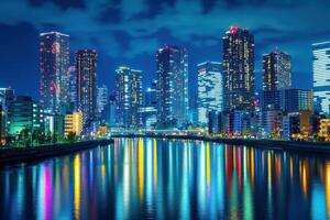 Vibrant city skyline at night with reflections in the calm river and illuminated skyscrapers photo