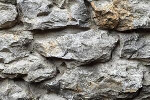 Textured gray stone wall with rugged rocks arranged in a natural pattern during daylight hours photo