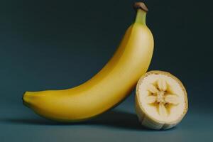 A fresh yellow banana and a sliced piece showing its inner texture on a dark background photo