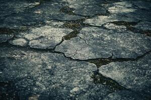 Cracked concrete surface exposed to the elements in a weathered urban environment photo