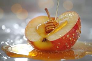 Fresh apple half covered in honey with sparkling droplets on a shiny surface photo