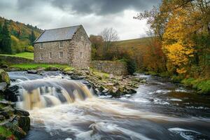 Charming stone house near a flowing river during autumn in a tranquil rural setting photo