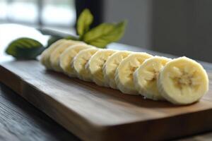 Sliced bananas arranged neatly on a wooden cutting board with natural lighting in a kitchen photo