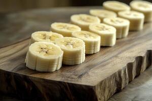 Sliced banana arranged neatly on a wooden cutting board for a healthy snack preparation photo