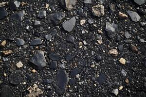 Close-up of a textured asphalt surface with various stones and gravel during daylight hours photo