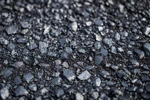 Textured asphalt surface with pebbles in a newly paved urban roadway during daylight photo