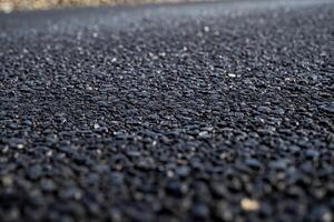 Close-up view of textured asphalt surface on a quiet suburban road during late afternoon light photo