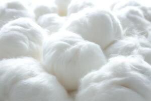 White cotton fibers arranged closely in a textile setting on a bright background photo