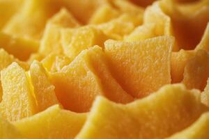Freshly sliced yellow mango arranged in a vibrant and colorful display on a smooth surface photo