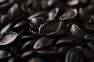 Close-up of harvested black seeds grouped together on a textured surface in natural light photo