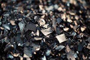 Close-up view of shiny black metal shavings in a workshop environment during daylight photo