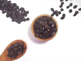 Roasted coffee bean on small wooden bowl and spoon isolated on white background with copy space photo