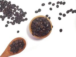 Roasted coffee bean on small wooden bowl and spoon isolated on white background with copy space photo