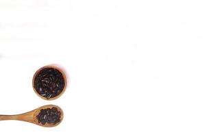 Roasted coffee bean on small wooden bowl and spoon isolated on white background with copy space photo