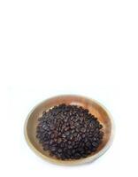 dish of roasted coffee beans on brown wood plate isolated on white background with copy space photo