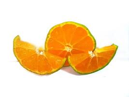 half lemon and slice isolated on white background. orange peel is green. photo
