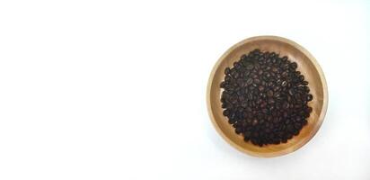 dish of roasted coffee beans on brown wood plate isolated on white background with copy space photo