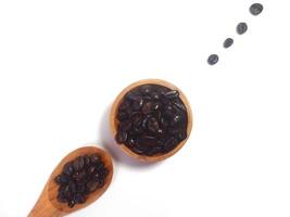 Roasted coffee bean on small wooden bowl and spoon isolated on white background with copy space photo